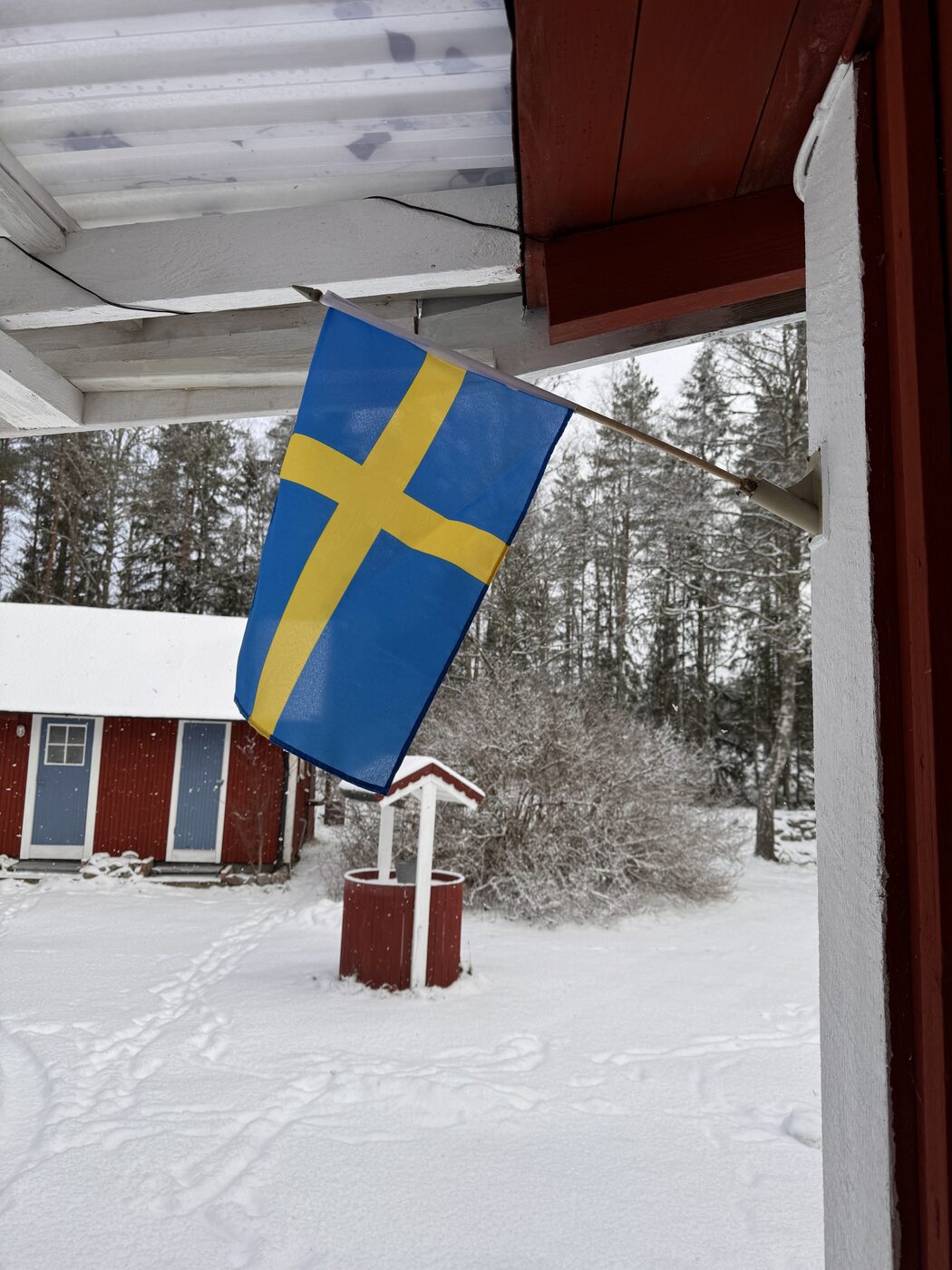 Schwedische Flagge am verschneiten Haus